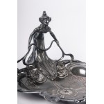 Lot of two pewter pocket empties France, first half of the 20th century 17 x 27 x 23.5cm; 14 x 21 x 17.5 cm one with an open triangular shape with a lady holding a stylised leaf, the other with an oval-shaped box with a pewter base and lid and a ceramic b