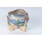 Triangular shaped centerpiece tub early 20th century 10 x 11 cm with three feet in the shape of a triton and decoration with a landscape and a putto. Probably manufactured in Pesaro State of conservation: large amounts of colour loss, Triangular shaped ce