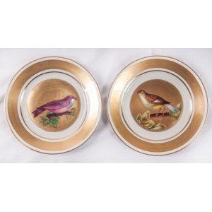 Lot of two knife plates 24.6 x 2.6 cm in polychrome porcelain, with a gilded brim and a pure gold rim. White background with a reproduction of a bird within a gilded reserve. On the back, a lowered background with a ring and a manufacturing signature in b