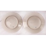 Lot of two knife plates 24.6 x 2.6 cm in polychrome porcelain, with a gilded brim and a pure gold rim. White background with a reproduction of a bird within a gilded reserve. On the back, a lowered background with a ring and a manufacturing signature in b
