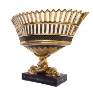 Centerpiece stand, Vienna, 19th century 27 x 17 x 8.5 cm in porcelain in the shape of an oval basket with a double ruff. Rectangular base on which rest a pair of invented fish that support the openwork basket. Base decoration in cobalt blue with floral fi