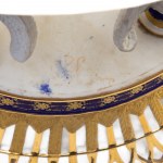 Centerpiece stand, Vienna, 19th century 27 x 17 x 8.5 cm in porcelain in the shape of an oval basket with a double ruff. Rectangular base on which rest a pair of invented fish that support the openwork basket. Base decoration in cobalt blue with floral fi