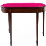 Mahogany book-style table late 19th century closed 73 x 91 x 45 cm; open 71 x 91 x 90 cm rectangular in shape with rounded corners and four tapered legs. Red cloth top, geometric decorative elements with fruitwood fillets along the top band and on the leg
