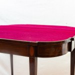 Mahogany book-style table late 19th century closed 73 x 91 x 45 cm; open 71 x 91 x 90 cm rectangular in shape with rounded corners and four tapered legs. Red cloth top, geometric decorative elements with fruitwood fillets along the top band and on the leg