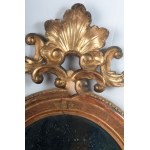 Oval shaped mirror in gilded and carved wood 19th century 114 x 56 x 9 cm with leaf-shaped top and legs with shell and scrolls. Angel heads decorate the frill of the mirror. State of conservation: some missing gilding., Oval shaped mirror in gilded and ca
