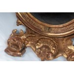 Oval shaped mirror in gilded and carved wood 19th century 114 x 56 x 9 cm with leaf-shaped top and legs with shell and scrolls. Angel heads decorate the frill of the mirror. State of conservation: some missing gilding., Oval shaped mirror in gilded and ca
