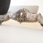 Free-standing mirror 1894 60 x 47 x 3 cm in 800/1000 silver and wood, with a curved line and two comma-shaped feet. Engraved parts, and in floral relief, coat of arms at the apex. Hallmark and signature at the base. Condition: good., Free-standing mirror 