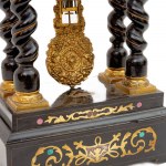 Table clock, second half of the 19th century 49 x 25 x 13.5 cm temple-shaped, in ebonized wood, with four twisted columns and brass fittings. Machine with steel plate suspension and pendulum regulator. White enamel dial with circular Roman numerals and tw