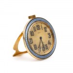 Art Déco gilded and enamel table clock Great Britain, 1910s - 1920s Height x width x depth: 7.3 x 8.6 x 1.8 cm. Weight: 259.1 g. Gilded and lavander guilloché enamels case, round shape. Golden color dial with Arabic numerals bearing the iscriptions 8 DAY