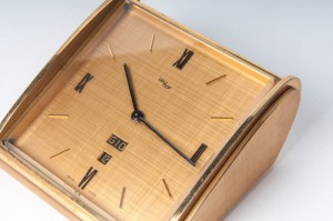 IMHOF Mosazné stolní hodiny druhá polovina 20. století 18 x 19 cm obdélníkového tvaru, mosazný ciferník s římskými číslicemi na osách, den v týdnu a datum na šesti hodinách. Ruční natahování. Stav: dobrý, strojově funkční, IMHOF Mosazné stolní hodiny druh