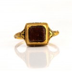 A Late Renaissanace gold and black enamel ring set with a garnet.