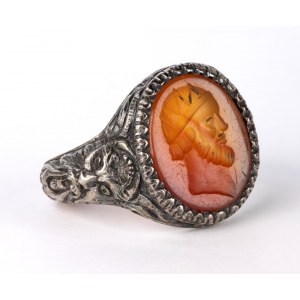 A postclassical carnelian intaglio set in a later silver ring. Male head.
