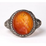 A postclassical carnelian intaglio set in a later silver ring. Male head.