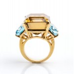 Gold band ring set with smoky quartz flanked by two blue topazes