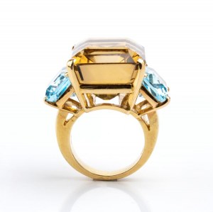 Gold band ring set with smoky quartz flanked by two blue topazes
