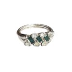 Silver (?) ring with green eyes and zircons