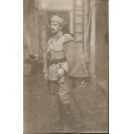 [Polish Legions] Photograph of soldier in LP uniform with saber, building courtyard in background. Ca 1915-1916.