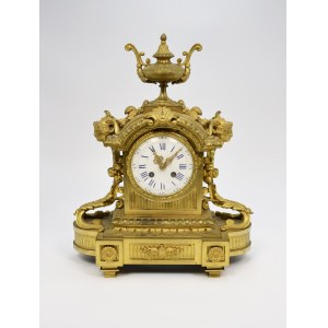 Mantel clock topped with a vase