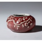 Small, low vase with plant decoration and oxblood glaze. China, 20th century.