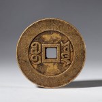A copper paperweight in the shape of a Jia Qing Tongbao coin. China, 19th century.