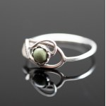 A filigree ring with a green eyelet.