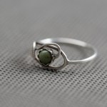 A filigree ring with a green eyelet.